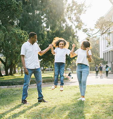 Young Couple Lifting up Daughter While Walking Outside